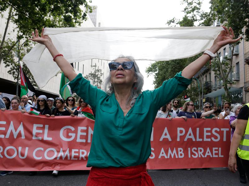A woman dressed in the colors of the Palestinian flag at the front of the march