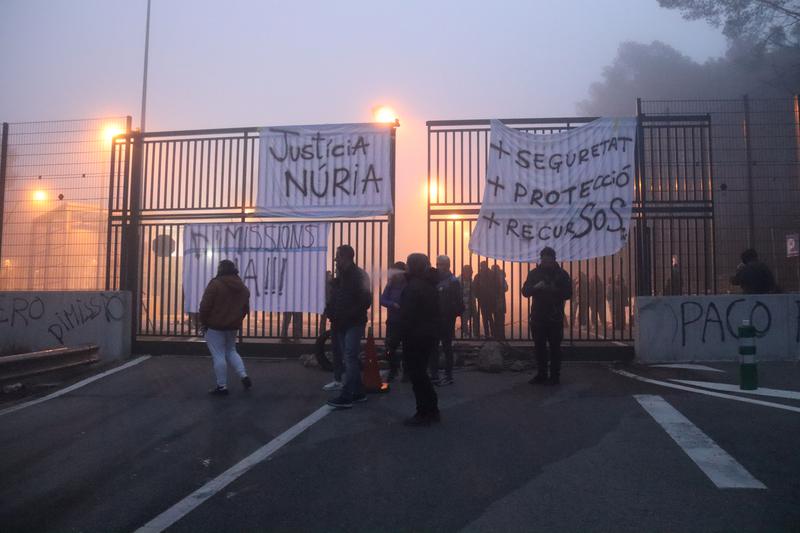 Staff from Mas d'Enric prison hang signs demanding justice for their colleague Núria, more safety, and sackings