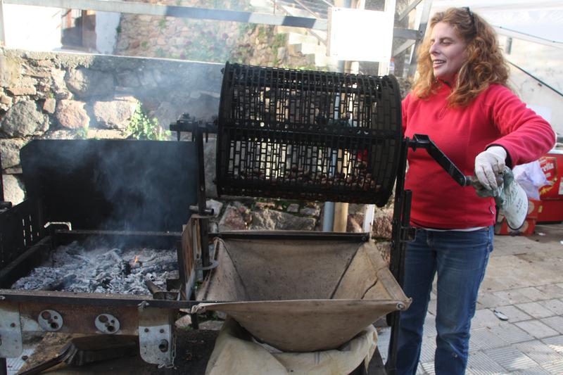 A woman roasts chestnuts at one of the many stalls across Catalonia for the Castanyada