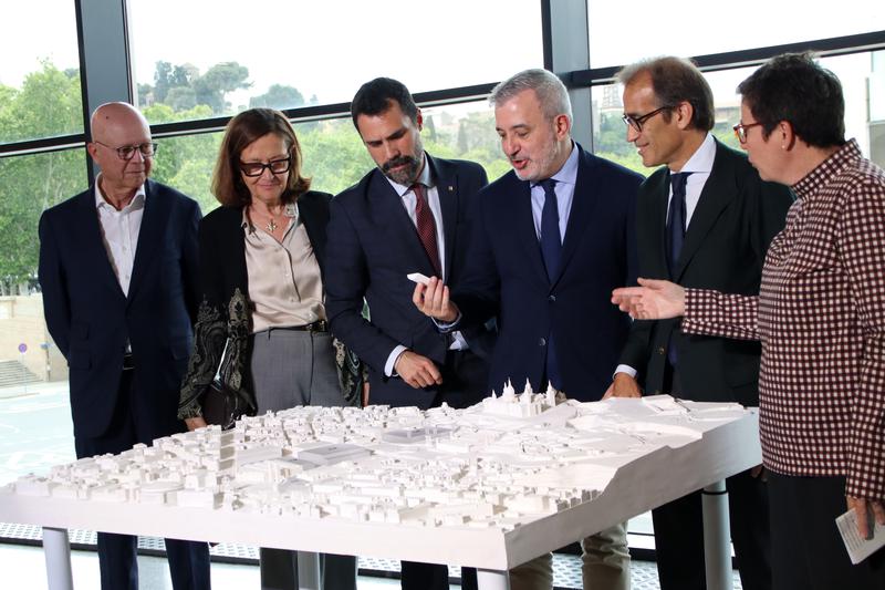 Barcelona mayor Jaume Collboni, business minister Roger Torrent and other officials examine a model of the Montjuïc exhibition space