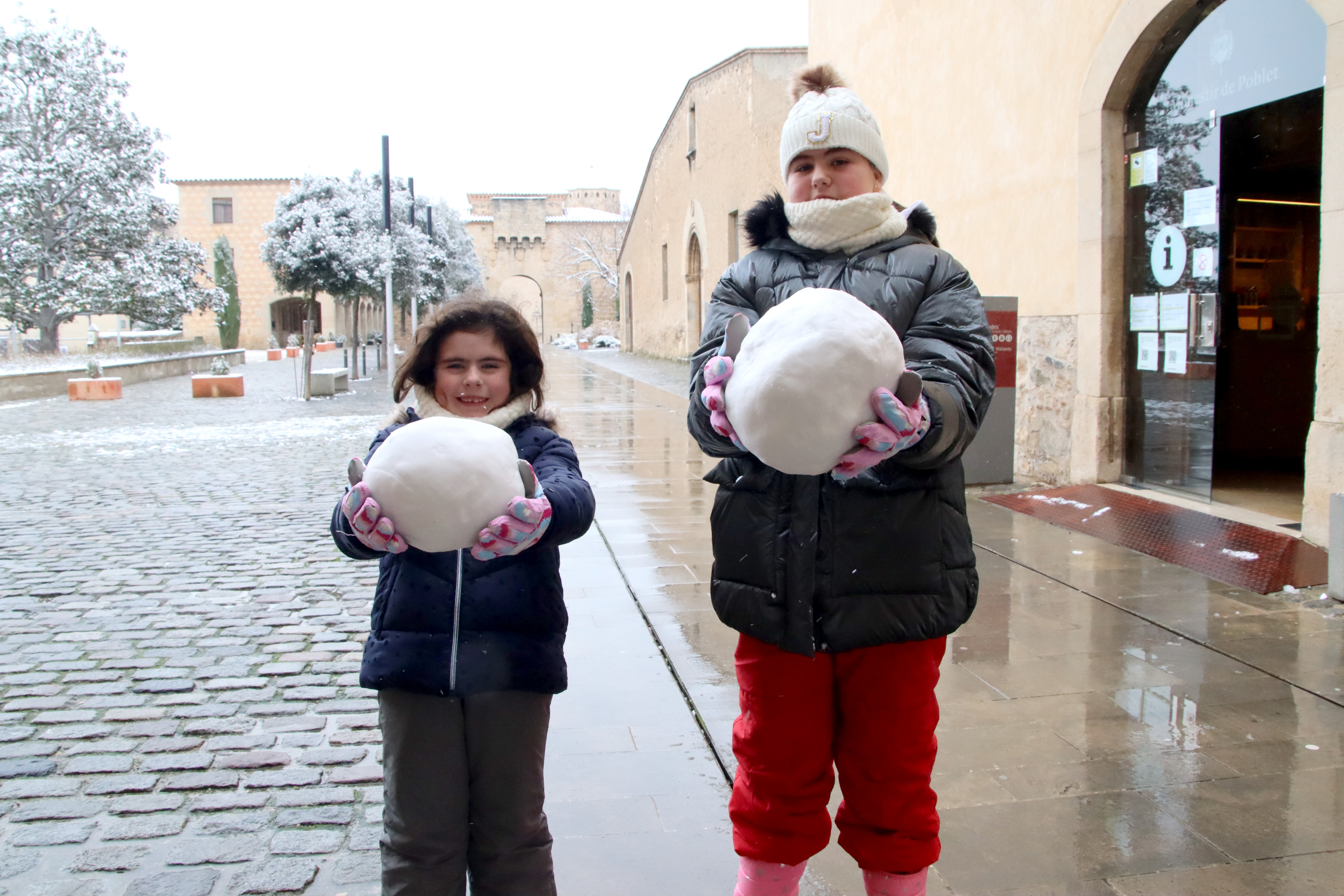 Children show the snowballs they made at the Poblet monastery