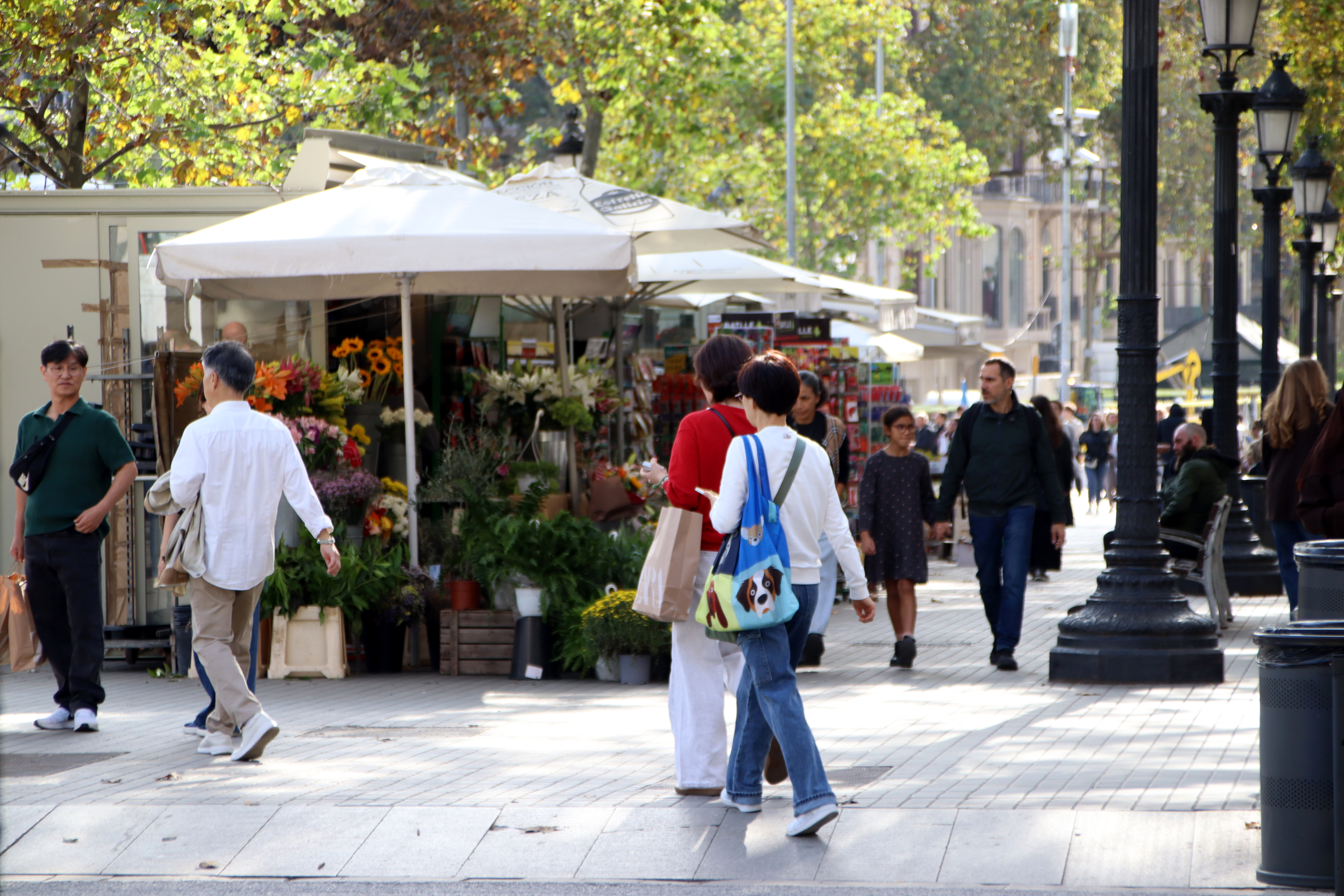 People walking past a flower stand on Plaça Catalunya in central Barcelona