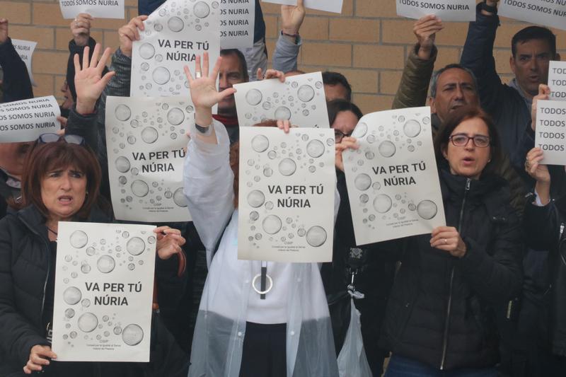 Prison workers hold up signs in memory of the cook killed in Mas d'Enric prison