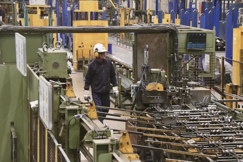 A factory worker oversees machinery at Transmesa's steel pipe plant