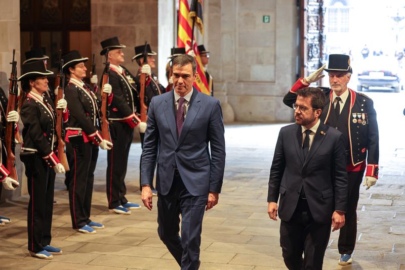 Catalan president Pere Aragonès and Spanish PM Pedro Sánchez walk in the Catalan government headquarters in front of the Mossos d'Esquadra police formation on December 21, 2023