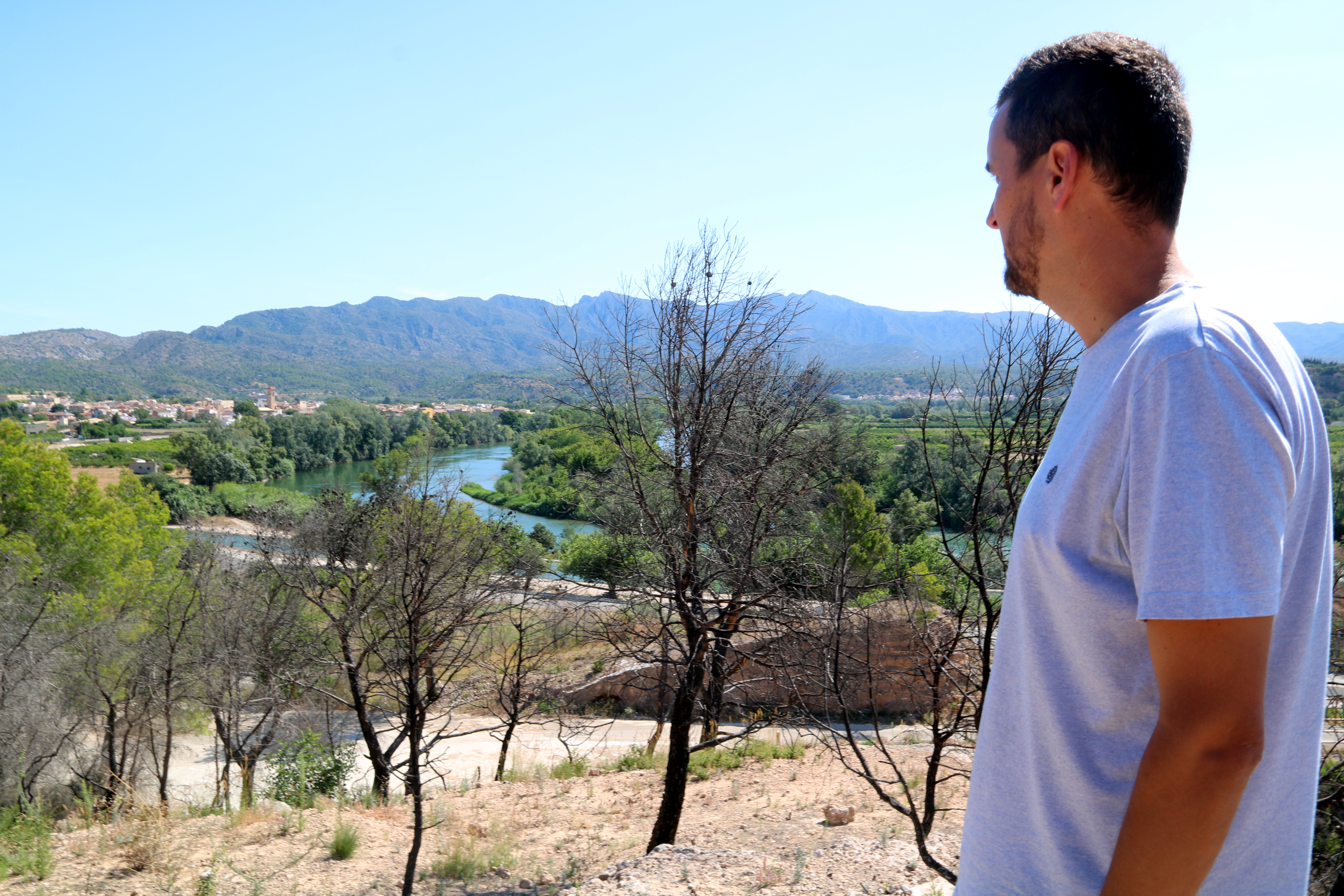 Xerta mayor Roger Aviñó looks out over the town from one of the areas burnt by the wildfire, where charred trees still stand
