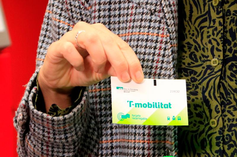 A commuter shows her new rechargeable T-Mobilitat paper transport card