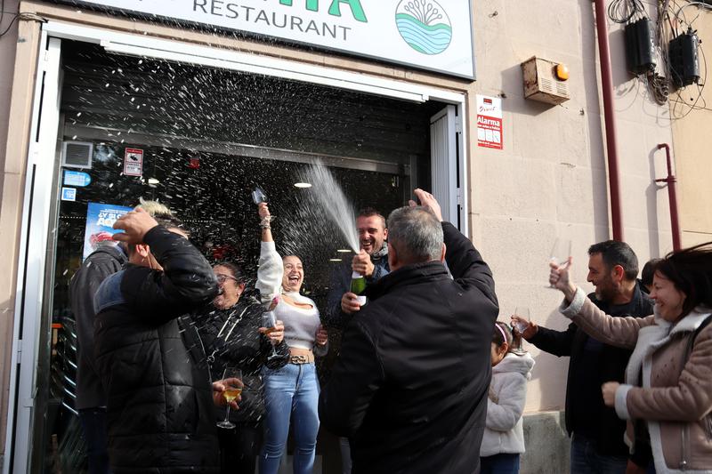 People in Barcelona's bar O'Limia celebrate after winning part of one of the fifth prizes at the 2024 Christmas lottery 