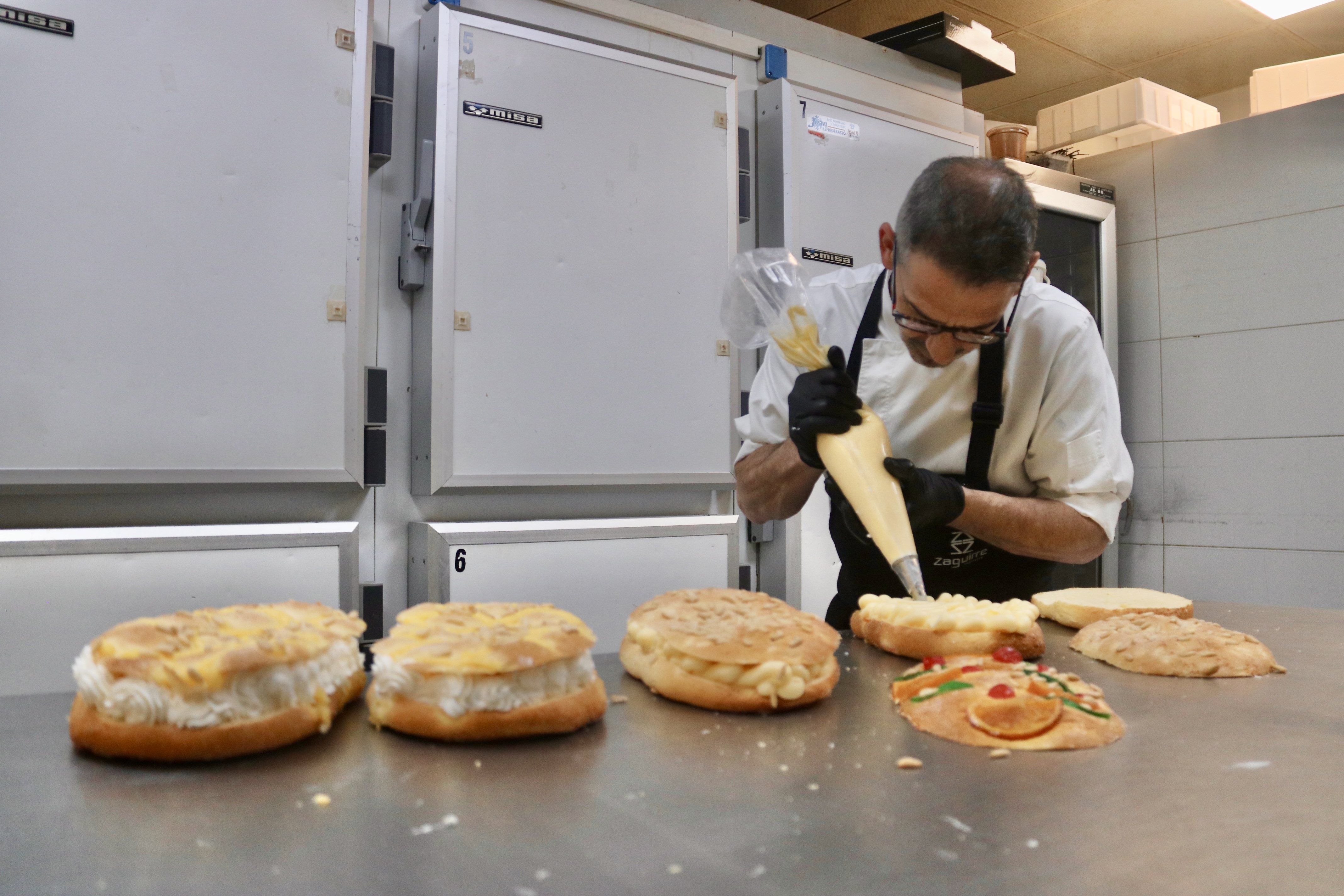 A pastry chef puts cream filling on a cake at the Zaguirre pastry shop.