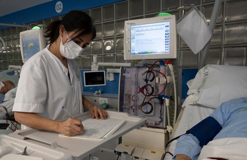 A medical professional at Hospital Clínic taking notes by hand after the cyberattack