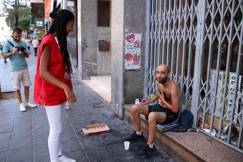 A Red Cross volunteer speaks with a homeless man in Tarragona