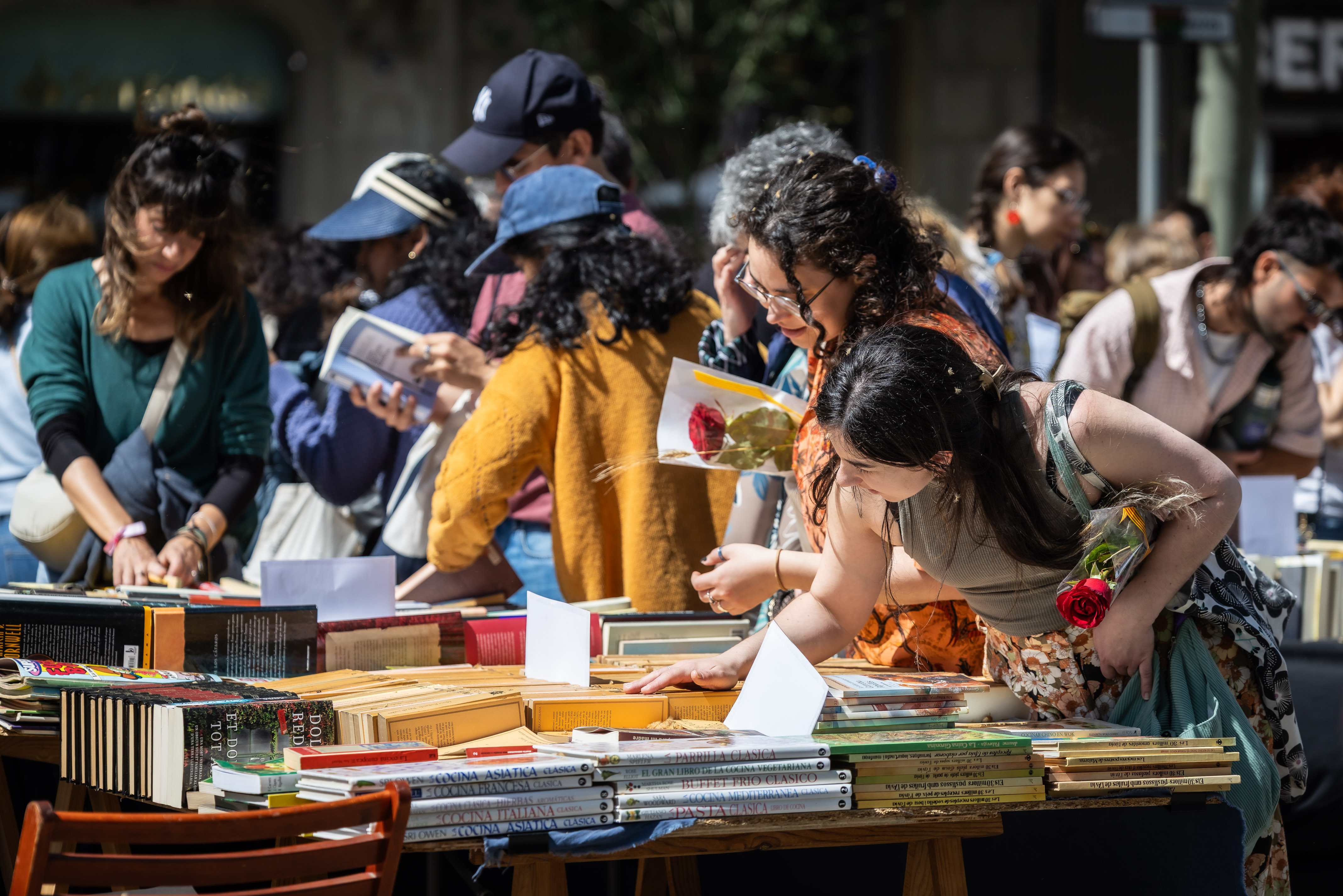 Two girls look at books at a stall in the center of Barcelona for Sant Jordi