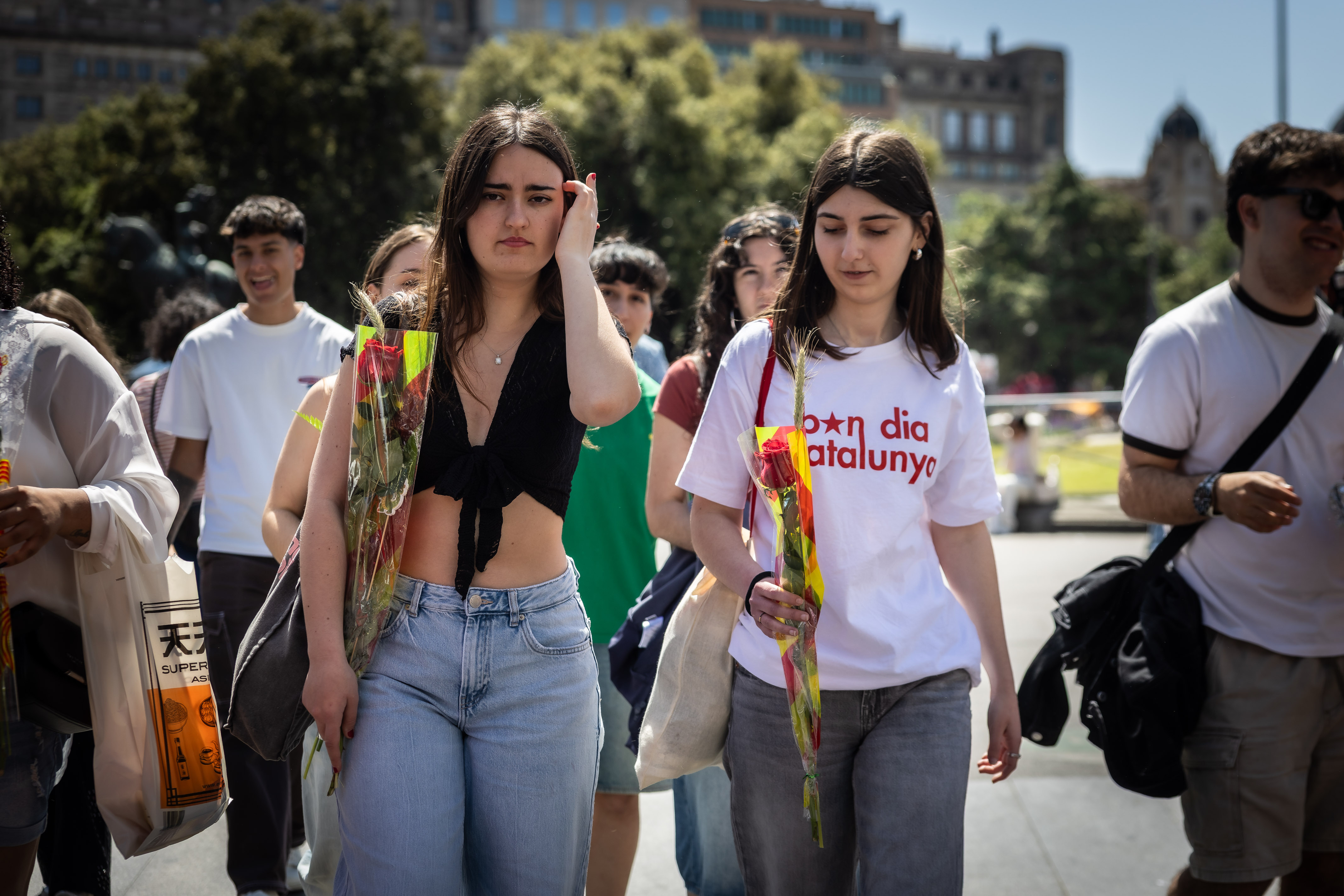 Two girls walk with a rose each on Sant Jordi