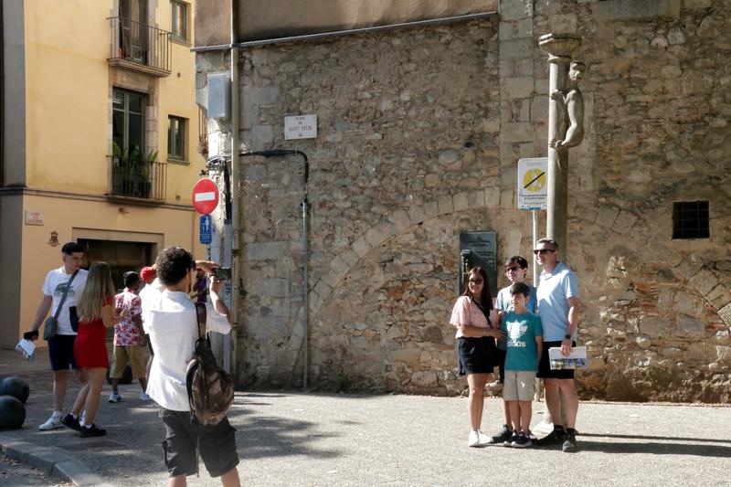 A family takes a picture with the Lleona lioness sculpture in Girona