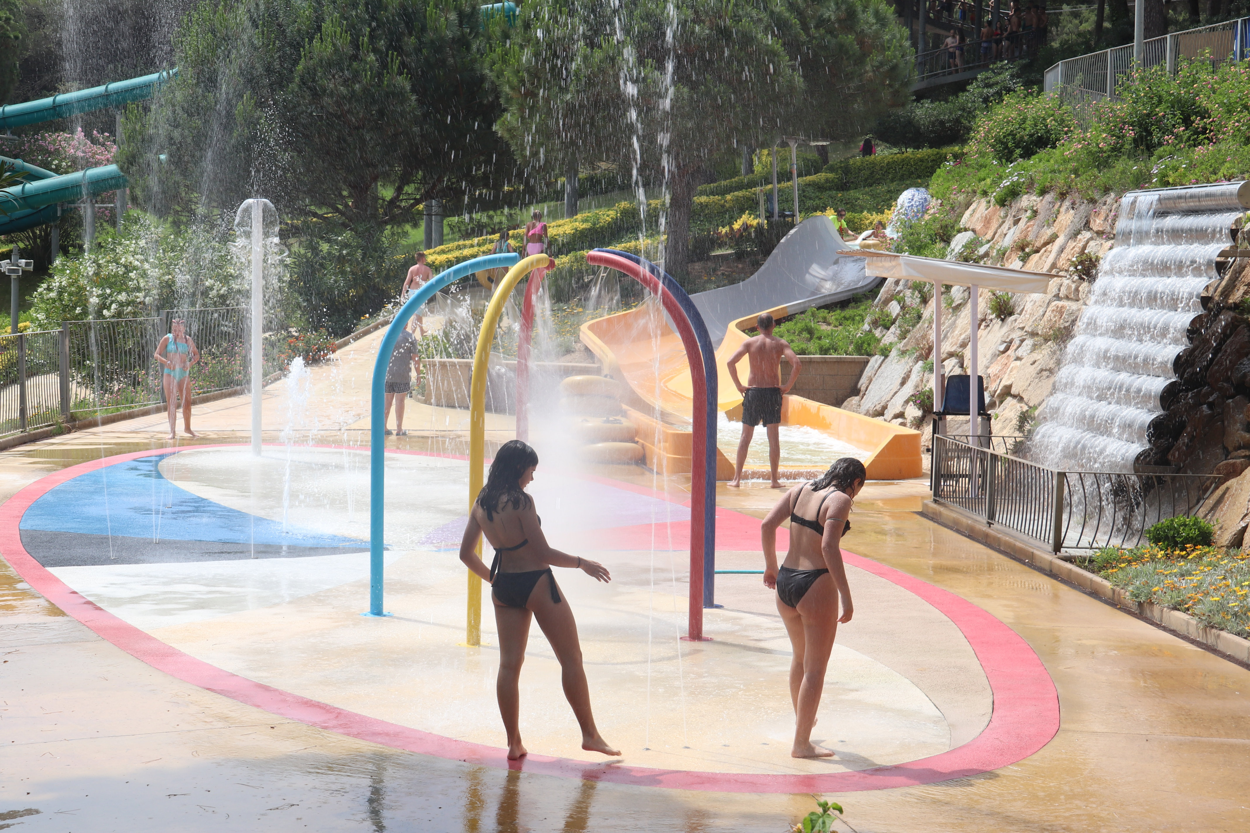 Two park goers get rained on by one of the attractions at Waterworld water park in Lloret de Mar