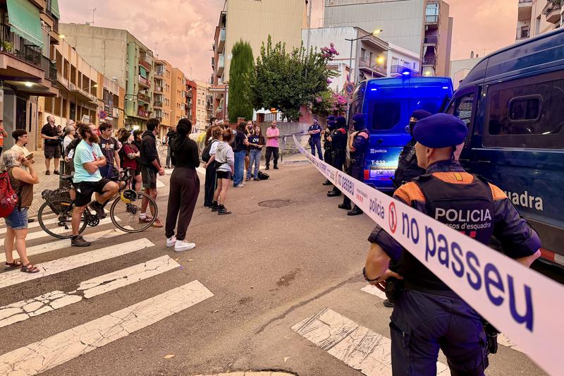 Neighbours and police officers outside the flat in Mataró where a family was evicted