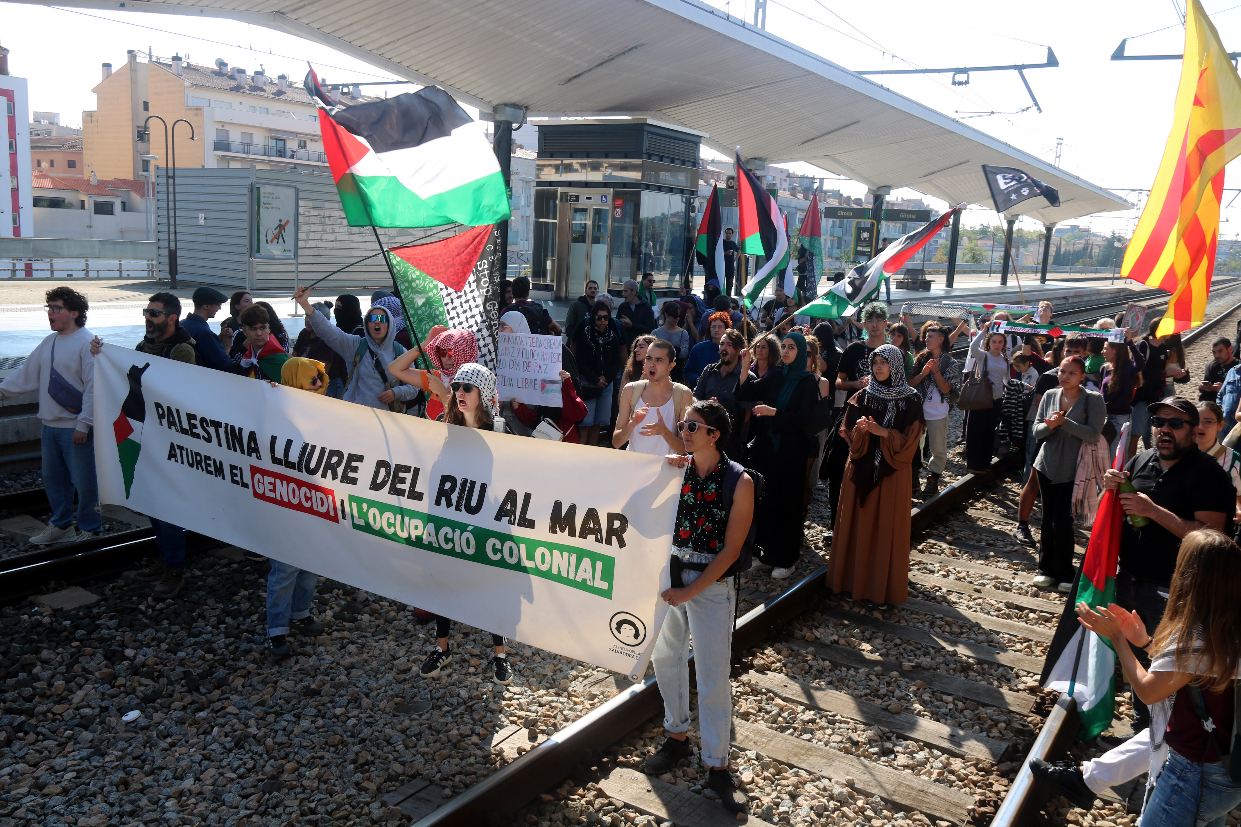 Demonstrators in Girona stand on railways to block trains from reaching the station on October 15, 2025 coinciding with a pro-Palestine strike