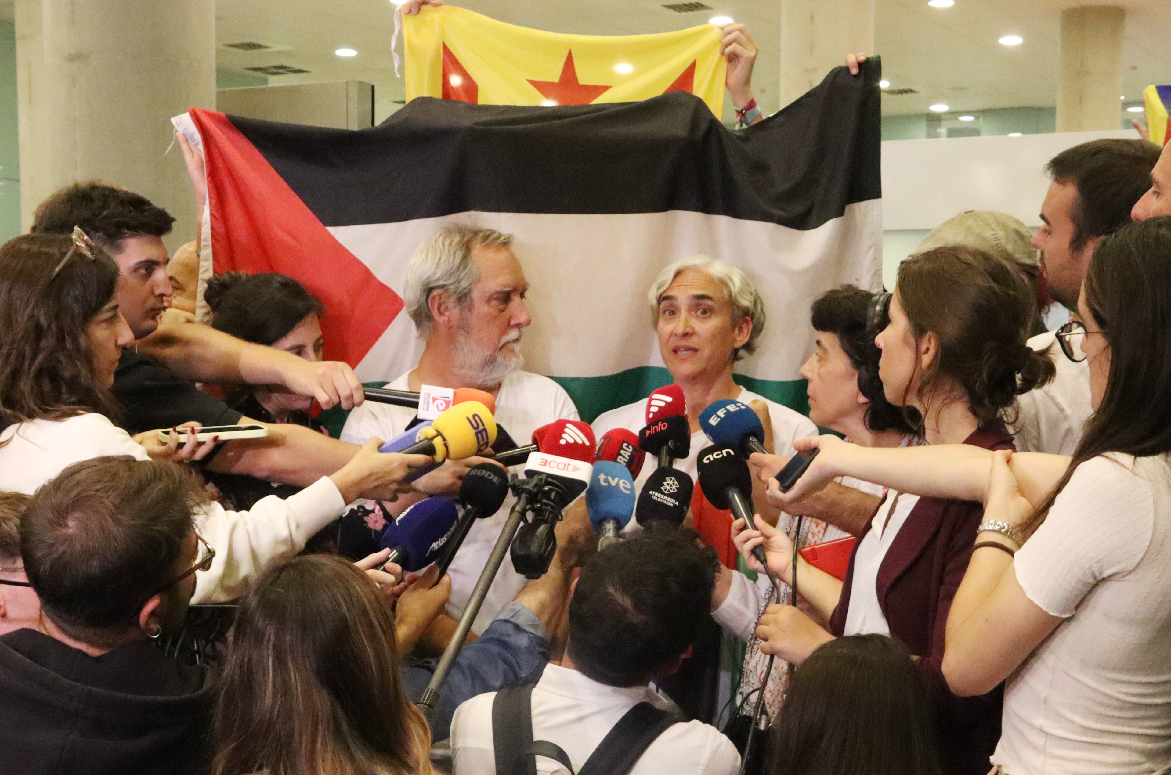 Former Barcelona mayor Ada Colau and Barcelona councilor Jordi Coronas speak to media outlets after landing at the Josep Tarradellas Barcelona El Prat airport on October 5, 2025