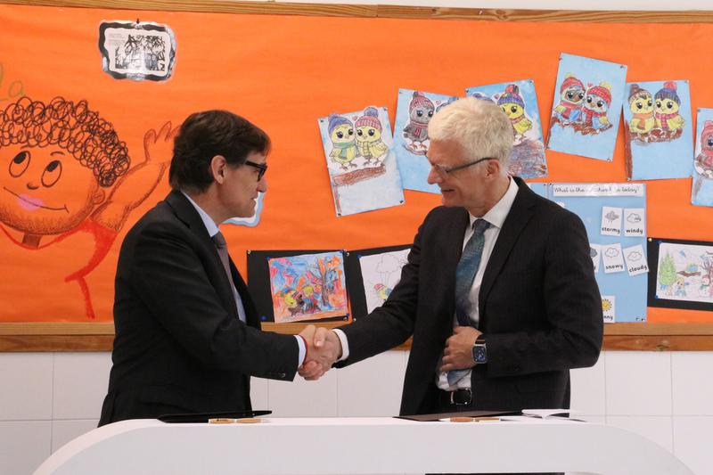 Catalan president Salvador Illa signing the agreement with the OECD director of education Andreas Schleicher