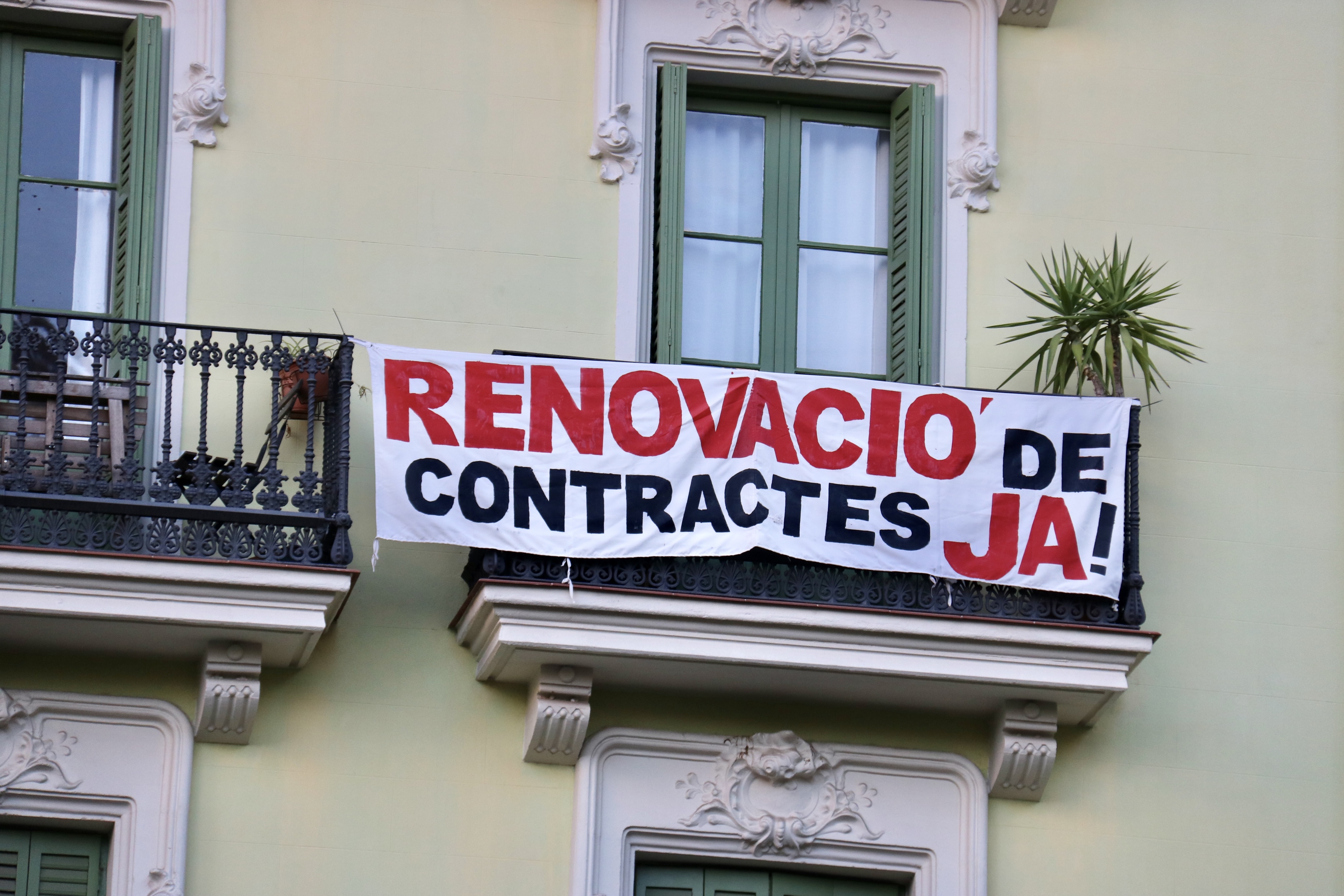 A poster hanging from a balcony in Casa Orsola reads 'contracts renewal now!'