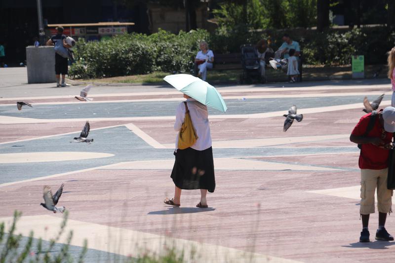 A woman protects herself from the heat with an umbrella in Barcelona