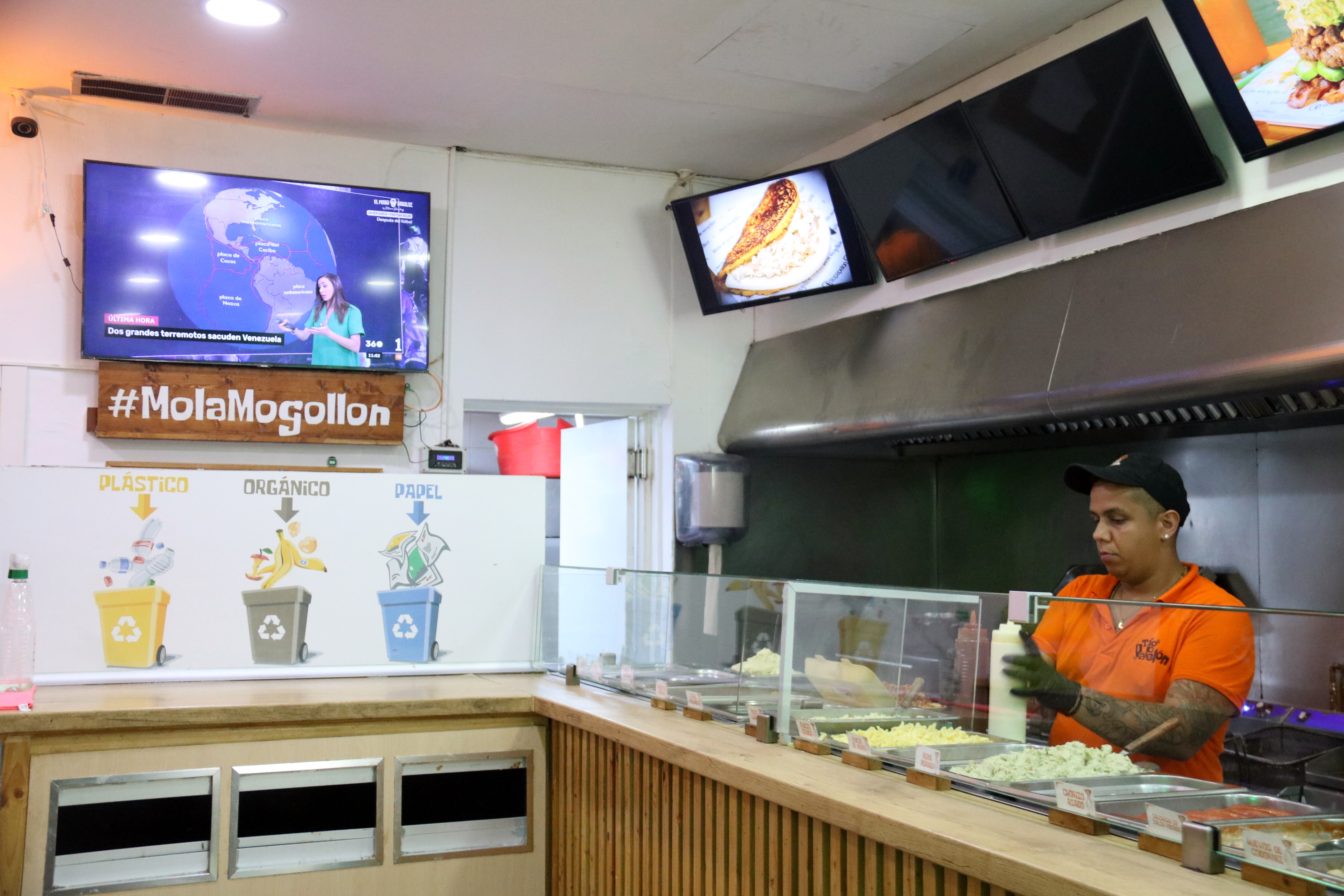 Ronald, who works in a bar specializing in Venezuelan cuisine, follows the news about the earthquake that has affected his country
