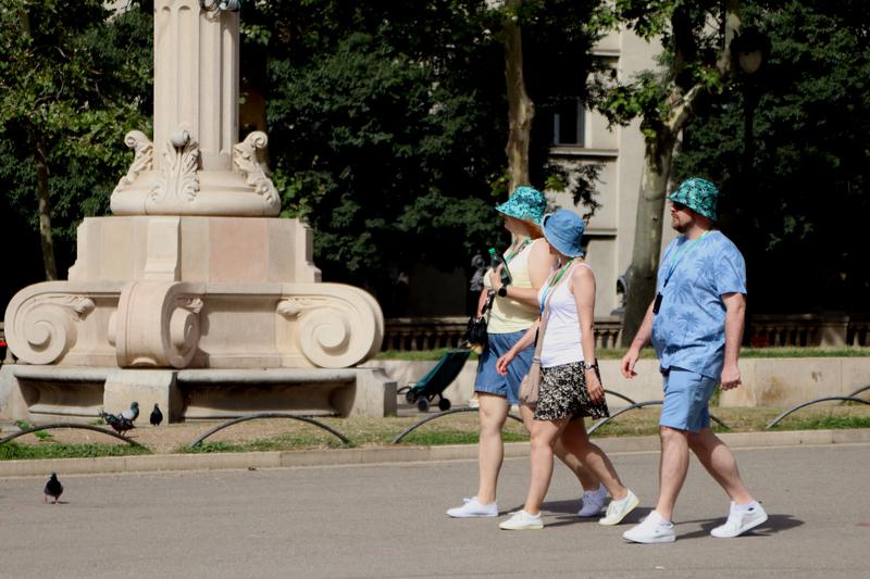 Tourists in Barcelona wear hats to beat the heat