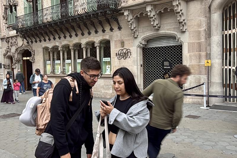 Members of the public on Passeig de Gràcia in Barcelona check the alert notification on their phone