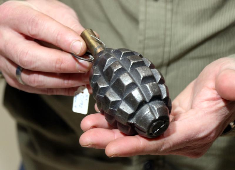 A police officer holds a Civil War-era hand grenade