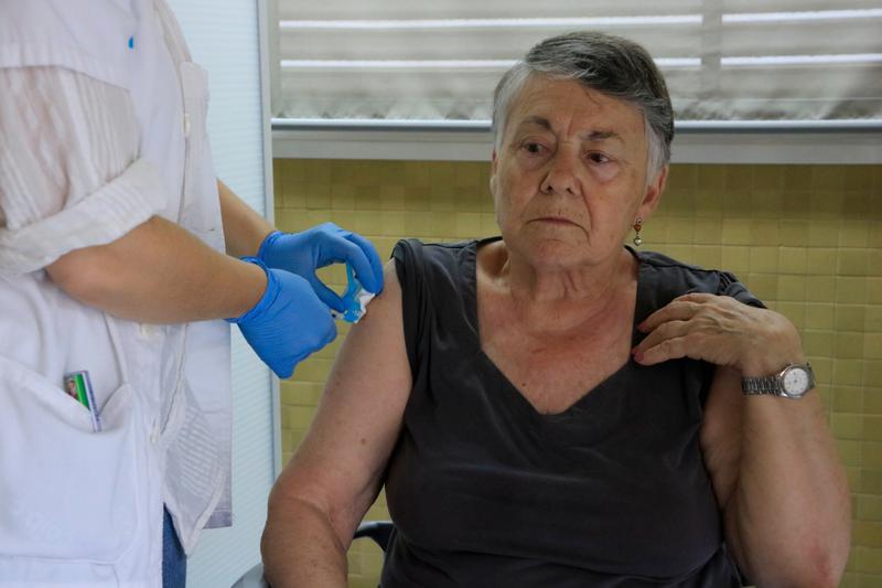 A woman receiving flu and covid vaccine