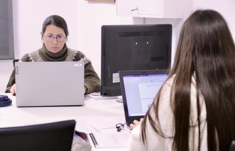 Two people working at laptops