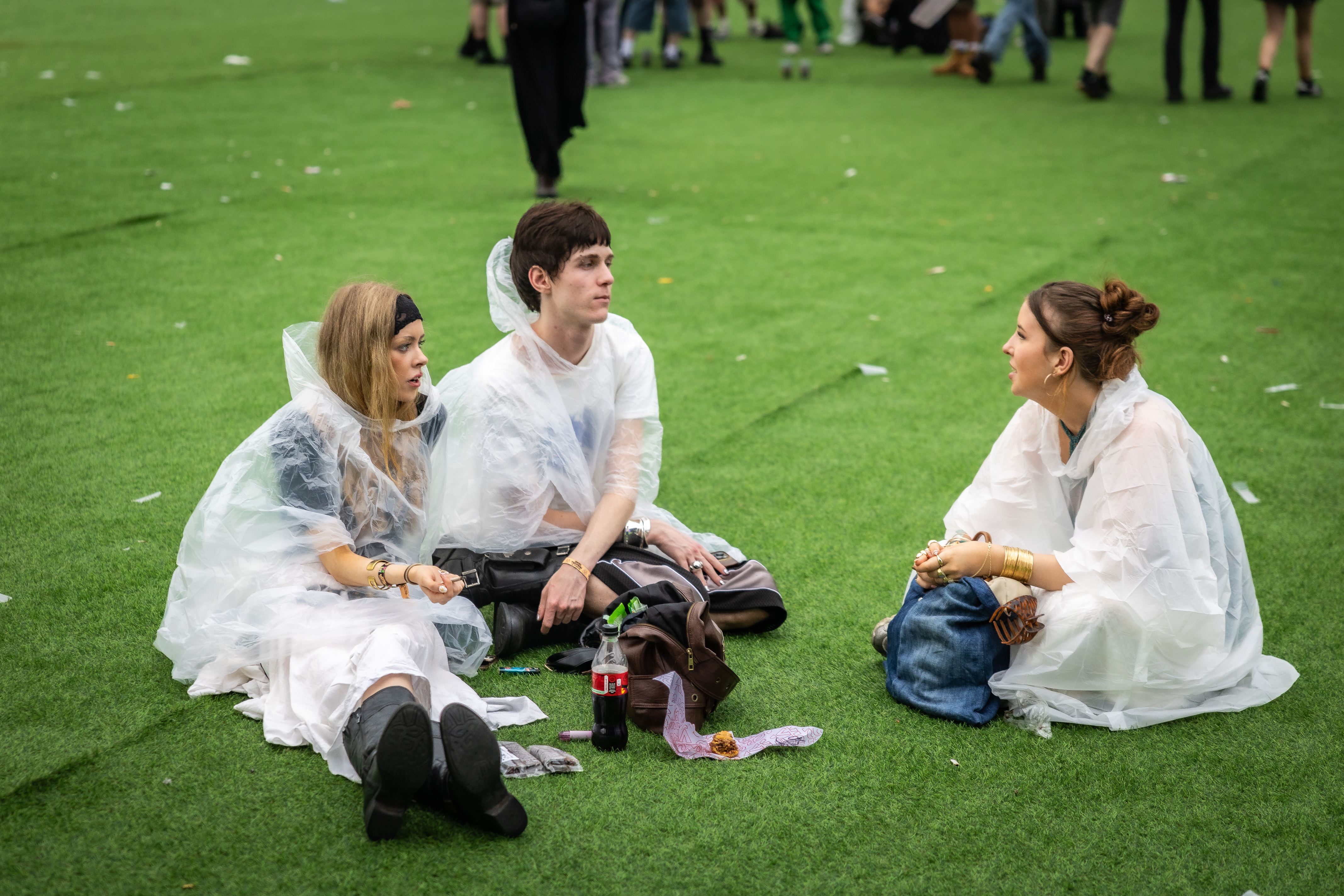 Festivalgoers in ponchos sit during Primavera Sound