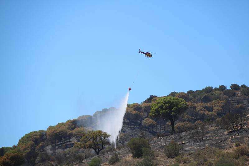 A helicopter tackles the wildfire in the Costa Brava town of Portbou on August 5, 2023
