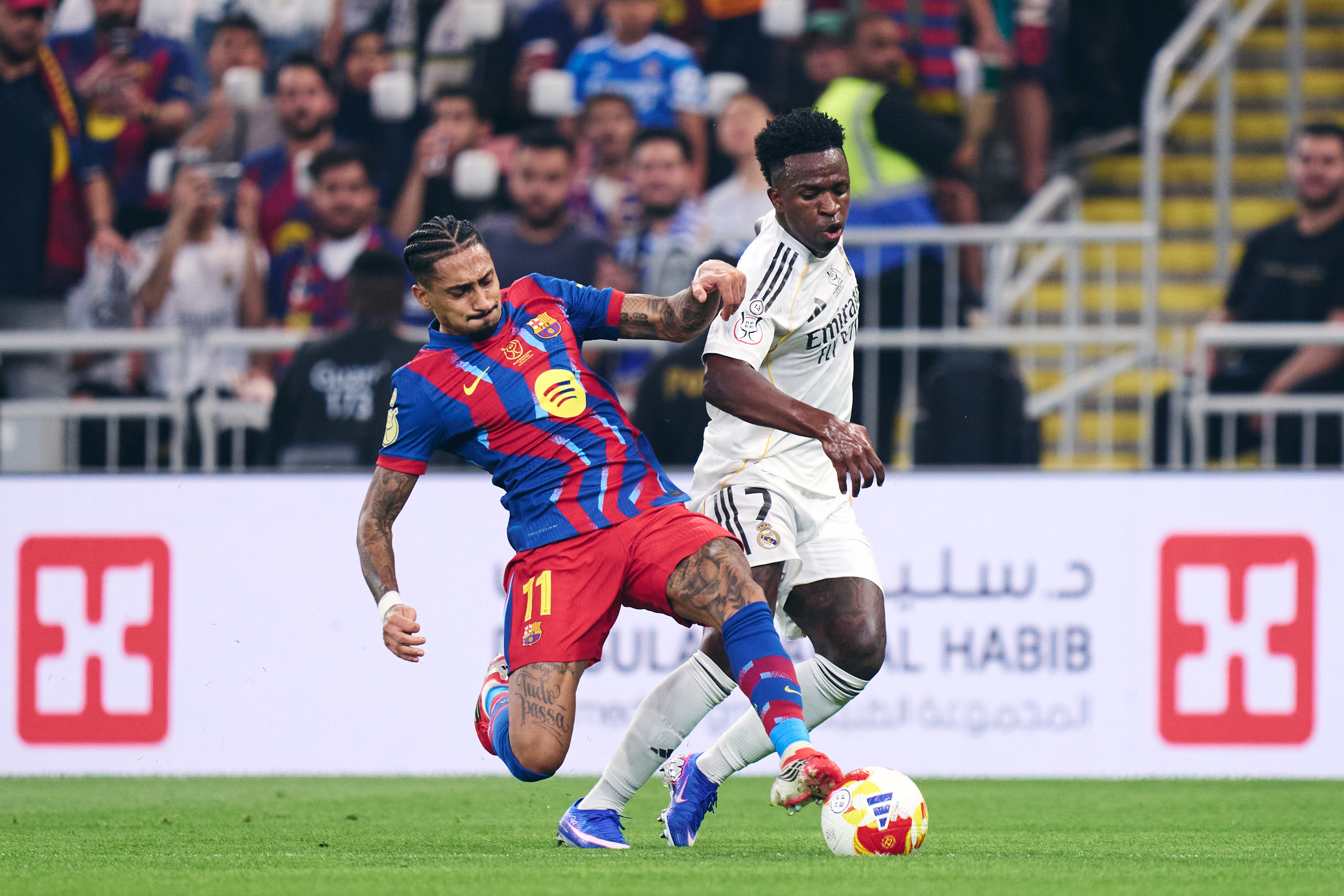 Raphinha clashes with Vinícius Júnior during the 2026 Super Cup final between FC Barcelona and Real Madrid CF at King Abdullah Sports City Stadium in Jeddah, Saudi Arabia