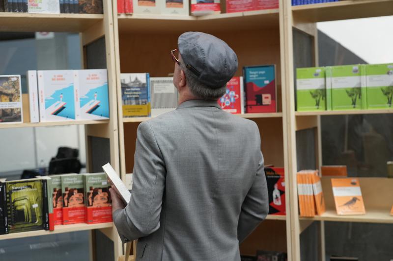 A man looking at books in the Barcelona pavilion of the Guadalajara International Book Fair