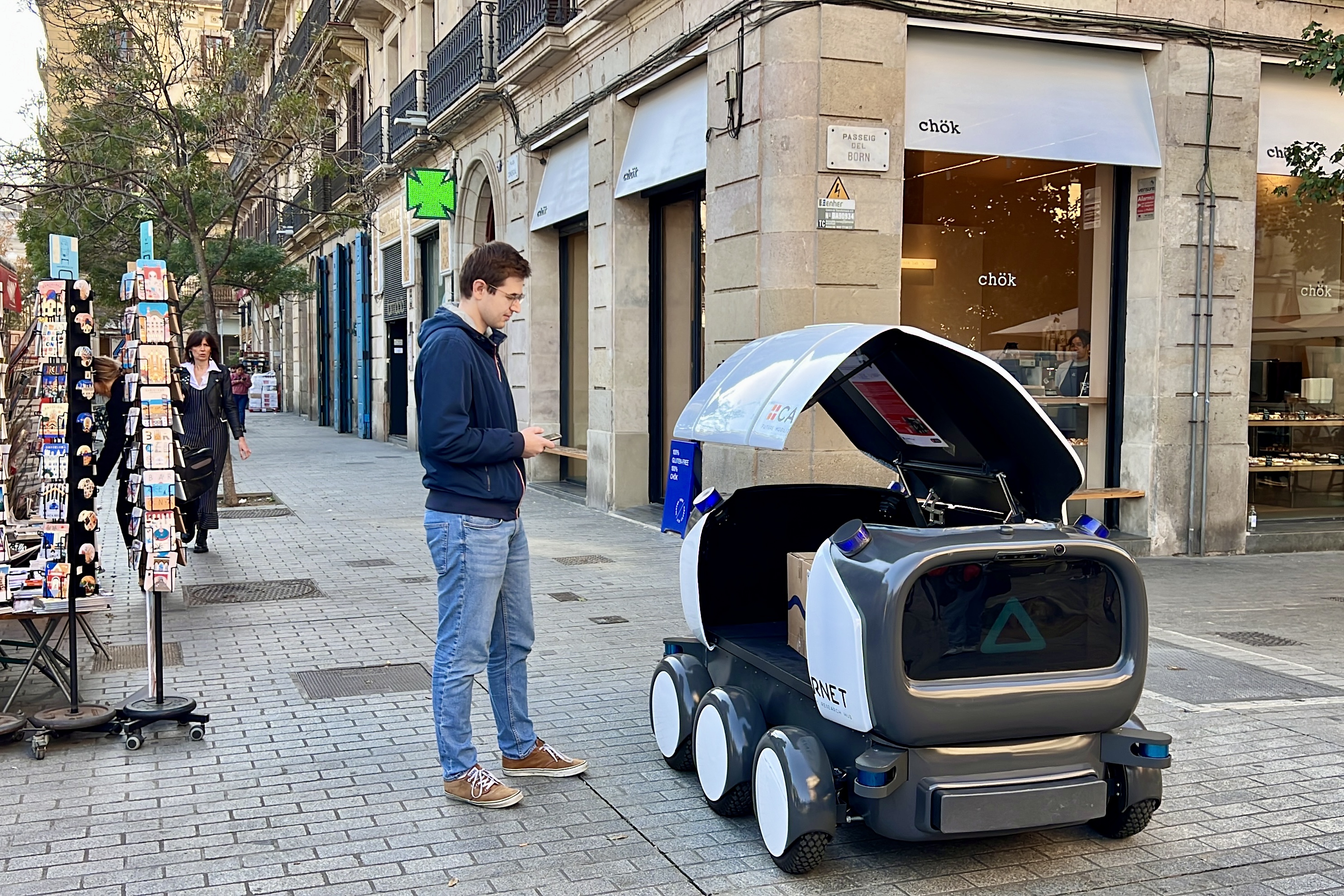 A person collects one of the packages inside Ona Robot during a test in Barcelona on November 19, 2024