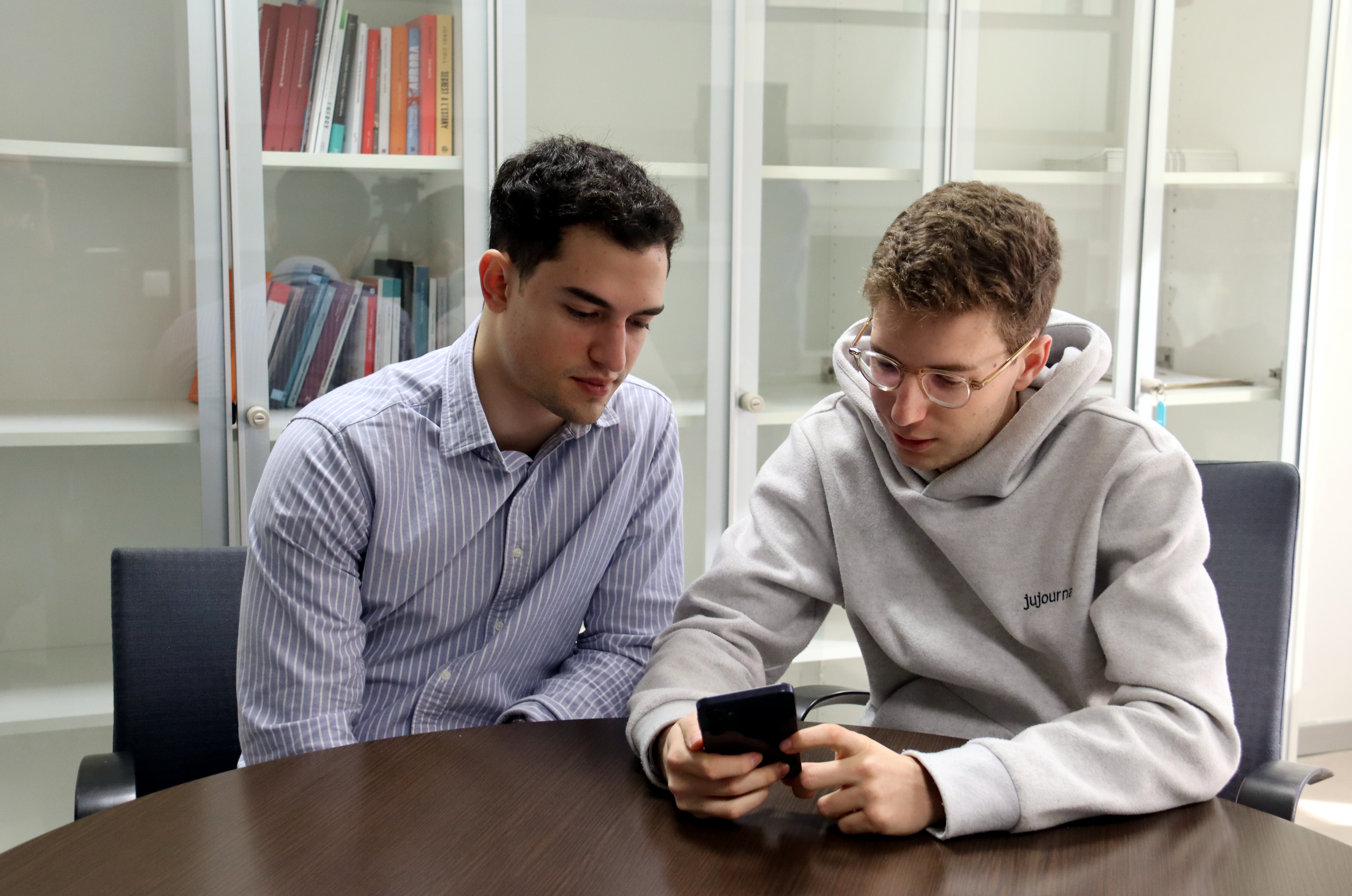 Albert Beltran (right), one of the founders of Balance Phone, looks at a device alongside addictions expert Jan Ivern