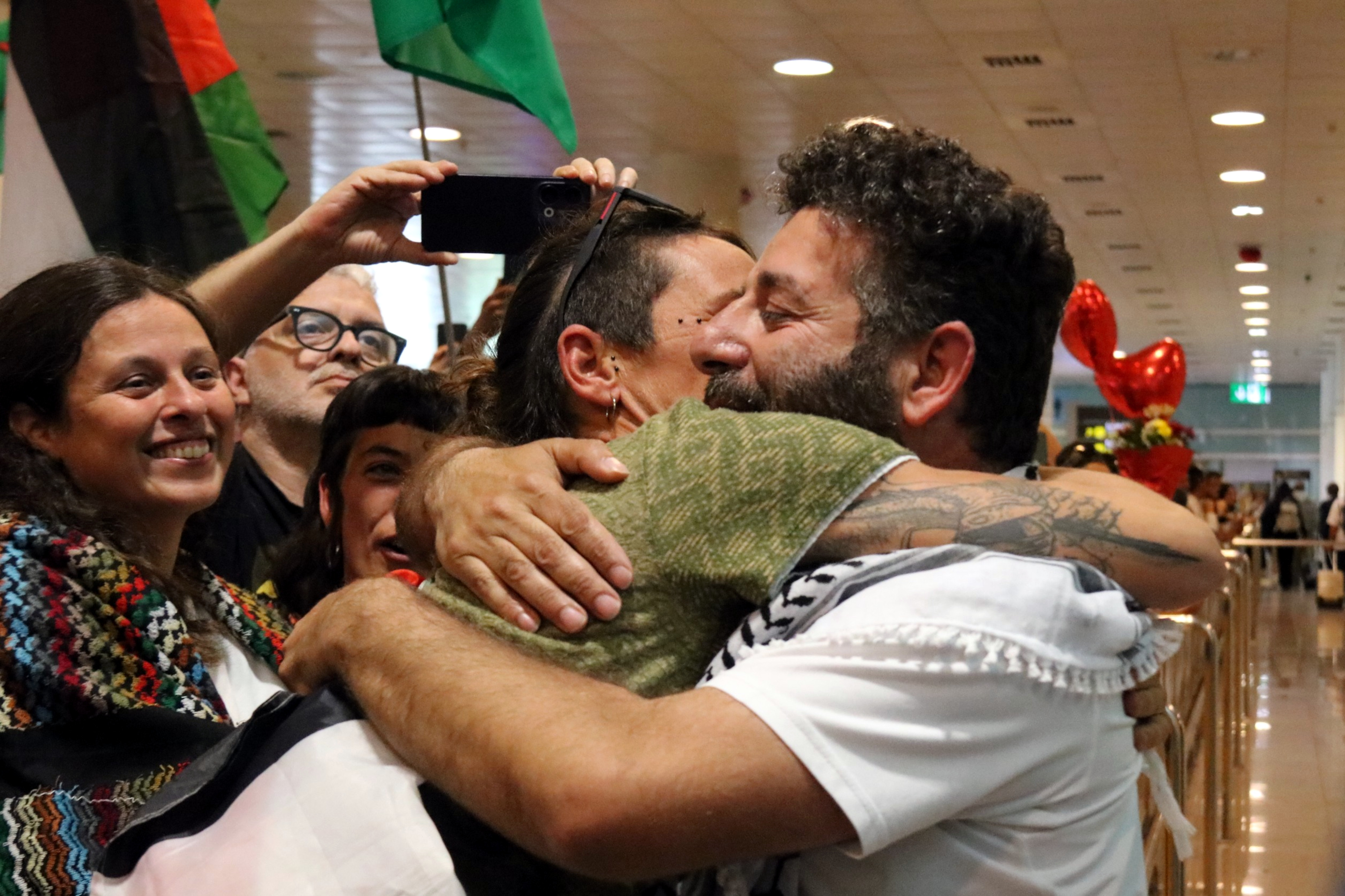 Activist Saif Abukeshek hugs a supporter upon arriving in Barcelona