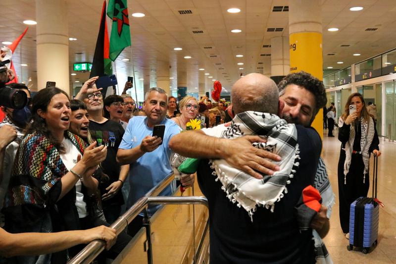 Activist Saif Abukeshek hugs a supporter upon arriving in Barcelona