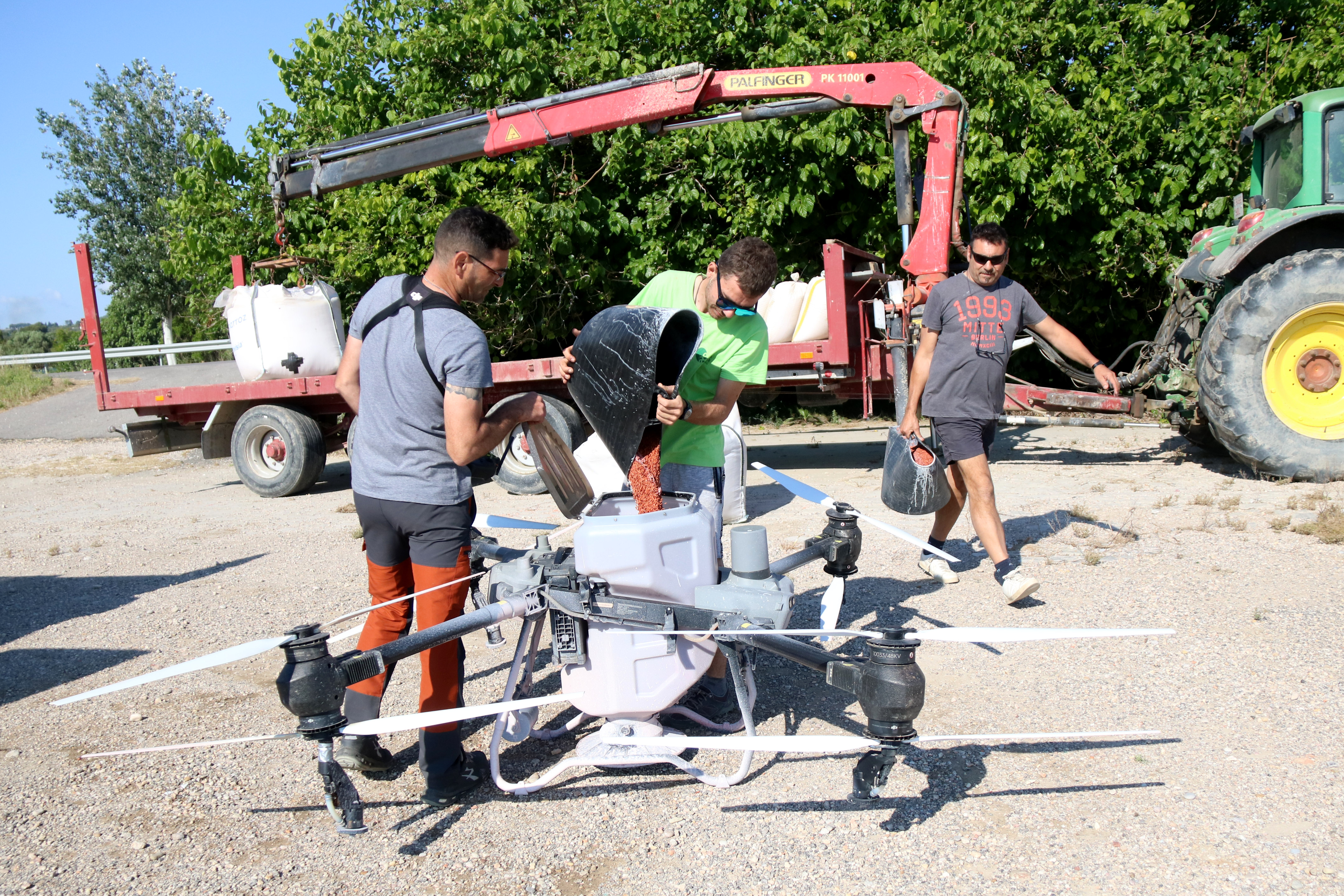 Farmers and technicians from Persual Drone preparing the device to sow a rice field in Ràpita