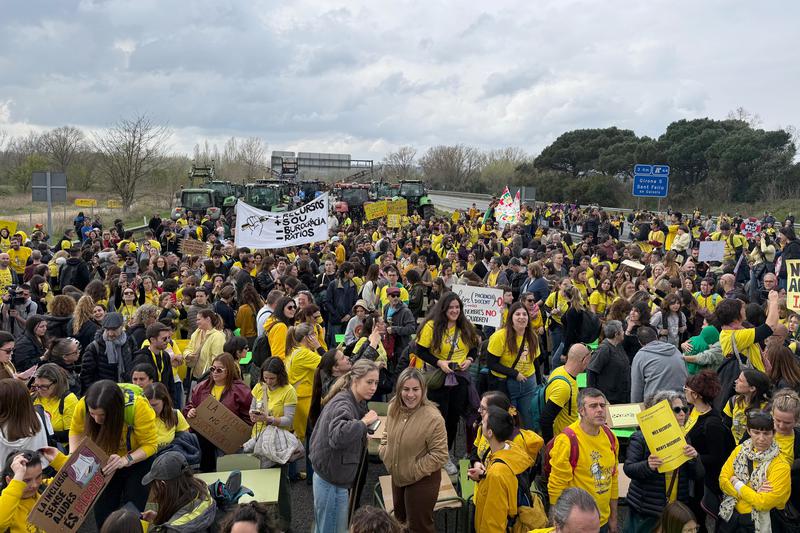 Teachers, doctors and farmers cutting the AP-7 in Sant Gregori with tractors in the background