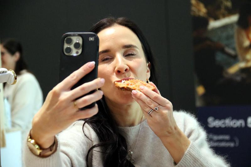 An influencer records herself eating a slice of 'pa amb tomàquet'