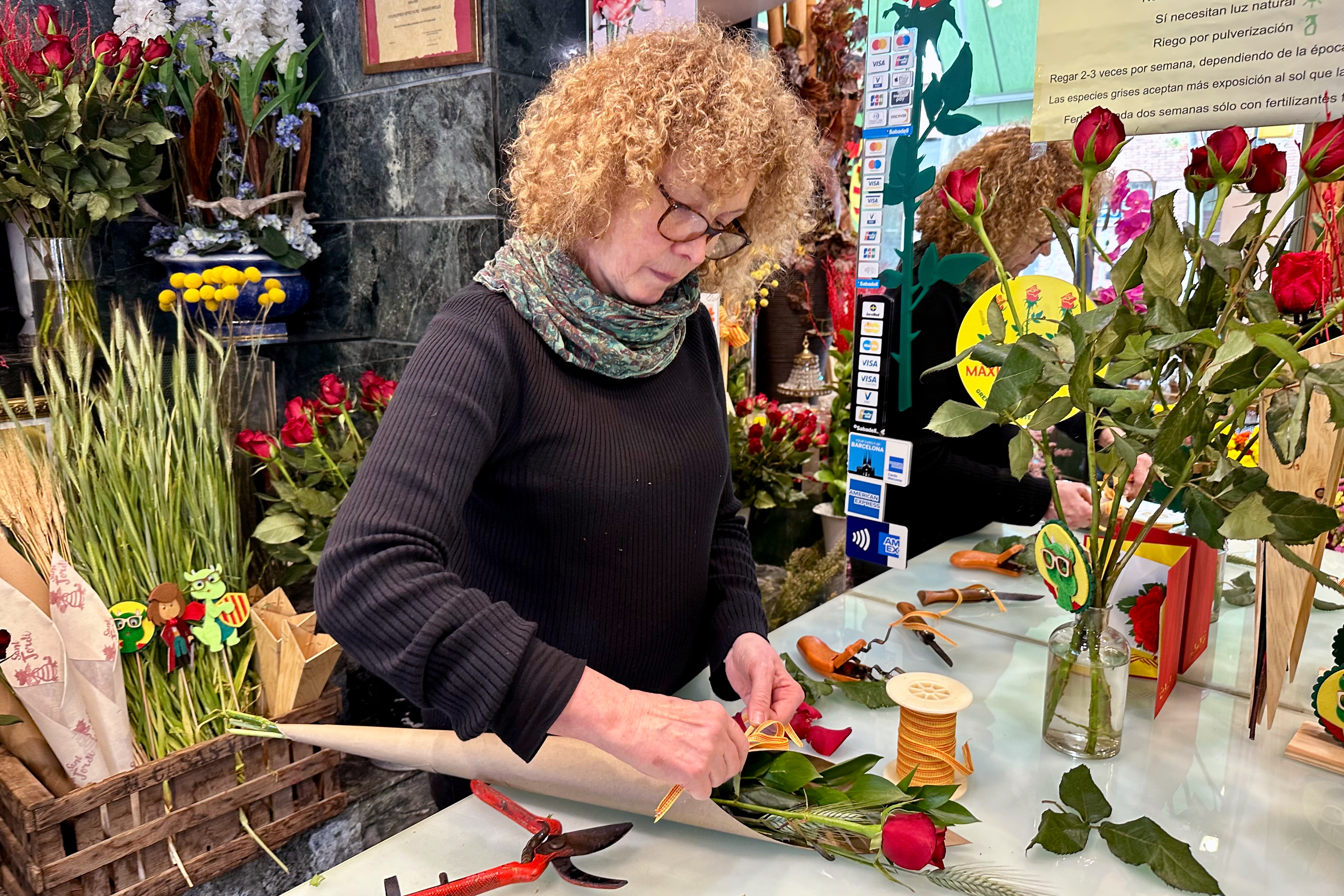 Elvira Casasús, the owner of Noves Flors flower shop, preparing a rose for Sant Jordi