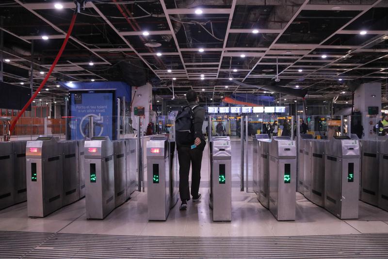 A passenger validates their ticket to enter Barcelona's Sants station to catch a Rodalies train