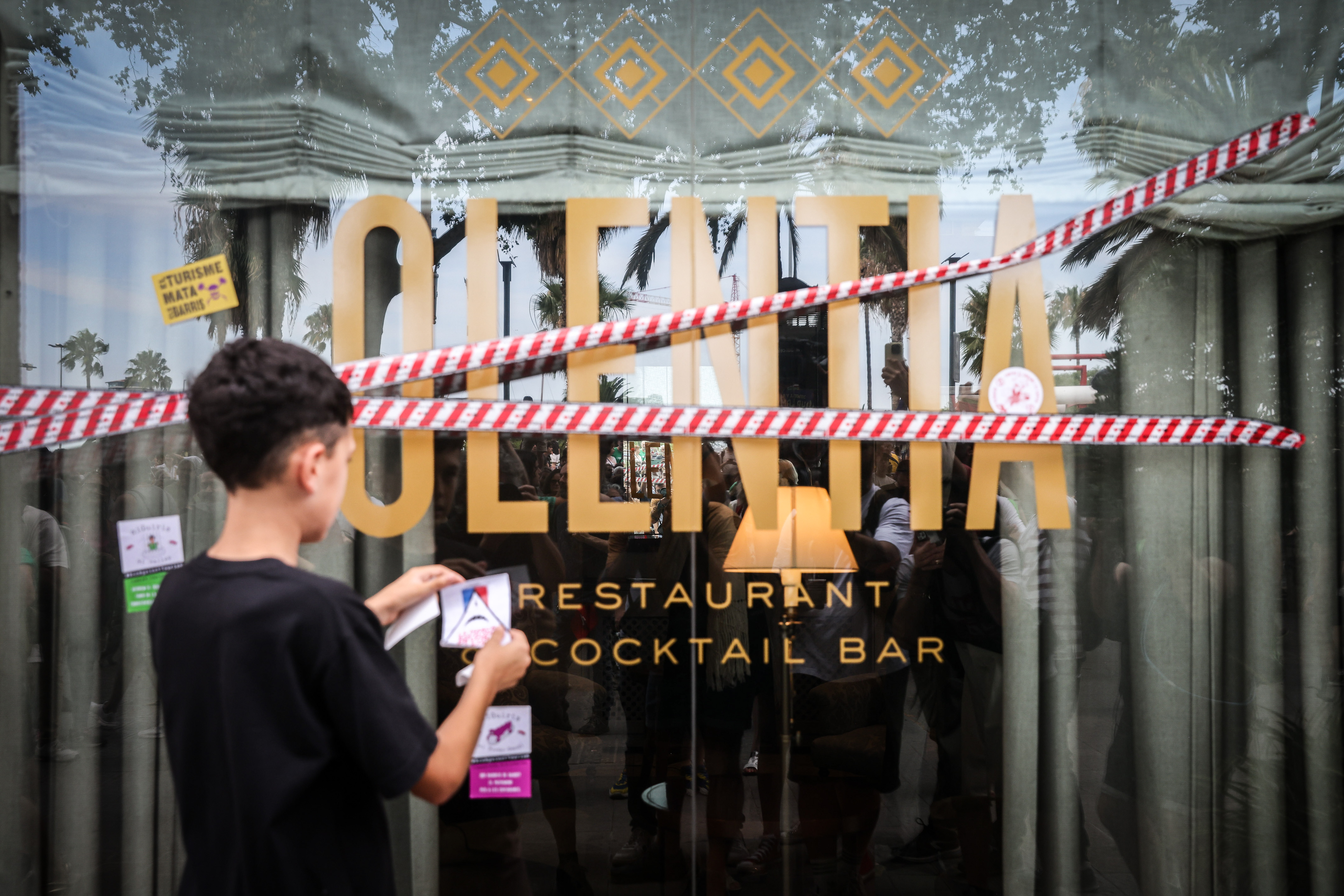 A cocktail bar and restaurant in Barcelona is surrounded by barricade tape during a demonstration against mass tourism on July 6, 2024.