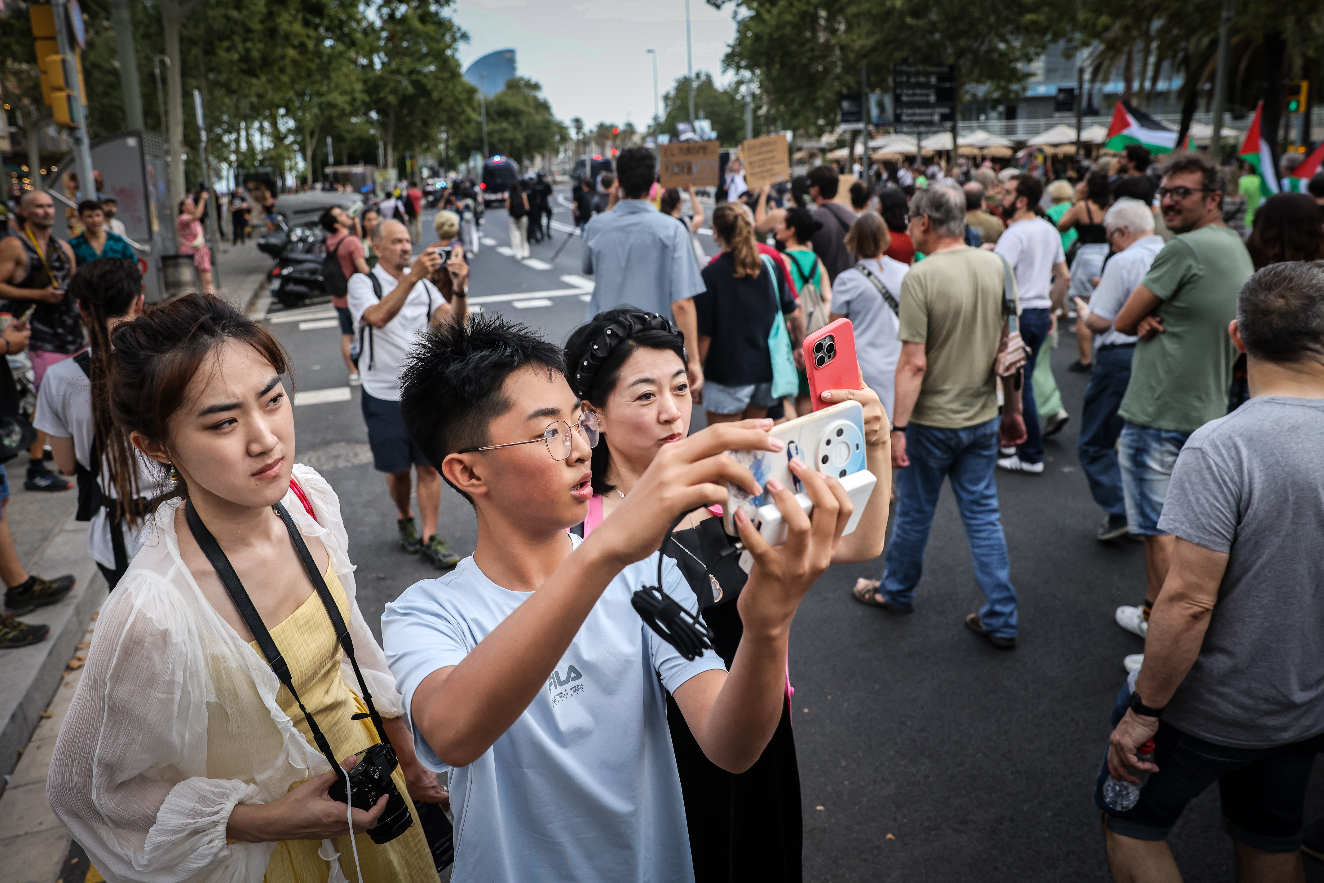 A group of tourists in Barcelona pose for a photo during a demonstration against mass tourism in the city center on July 6, 2024.