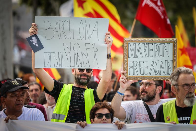 Placards at an anti-mass tourism rally read 'Barcelona is not Disneyland' and 'Make BCN Free Again'