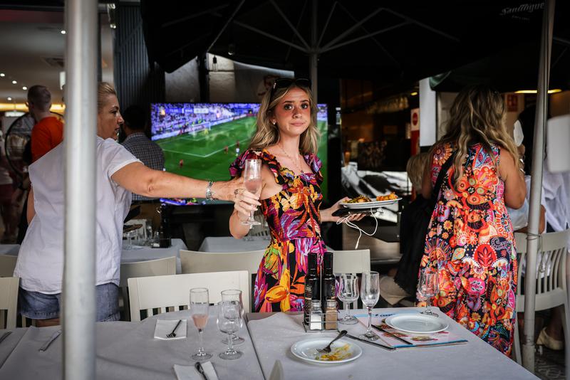 Tourists leave restaurant terrace as protesters spray them with water guns