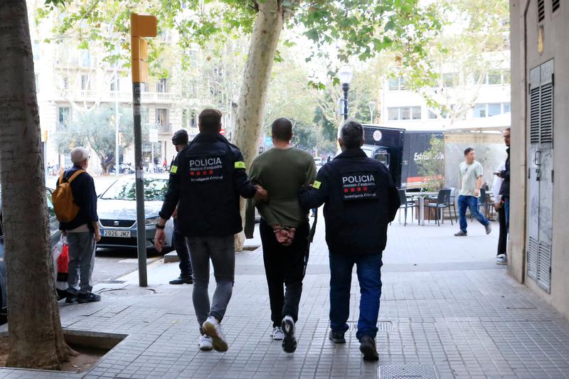 Catalan Mossos d'Esquadra police carry a detainee around Barcelona after a police raid on October 17, 2023