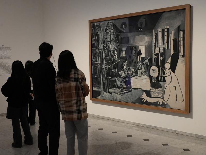 Visitors looking at a painting in the Picasso Museum in Barcelona